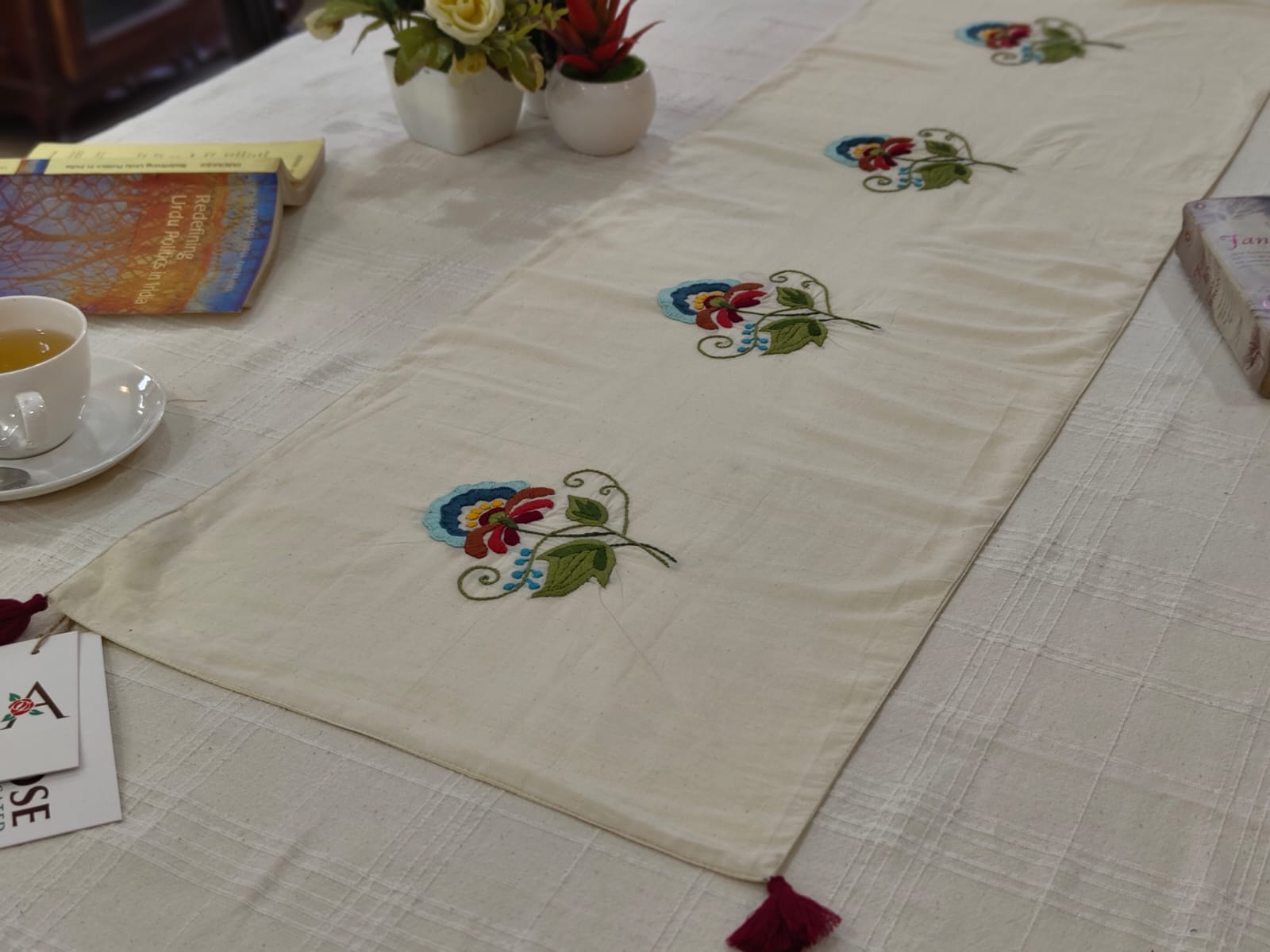 Embroidered table runner with floral patterns on a dining table.